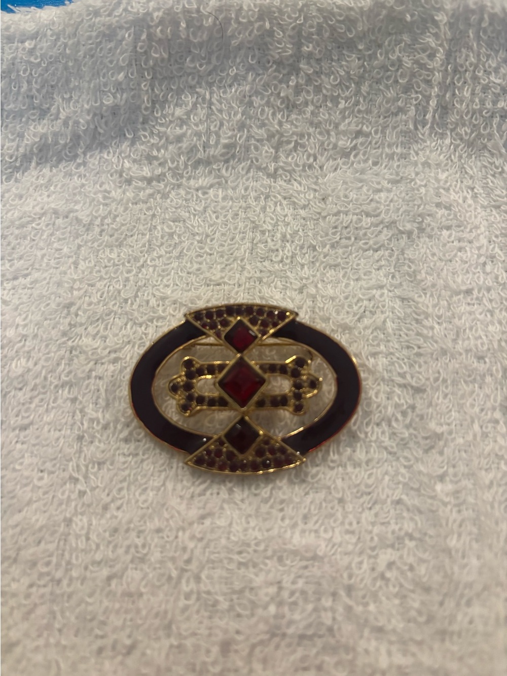 Oval brooch with red rhinestones